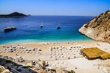 People enjoying sun and sea at the beautiful turquoise sea and sandy beach of Kaputas. aerial drone...