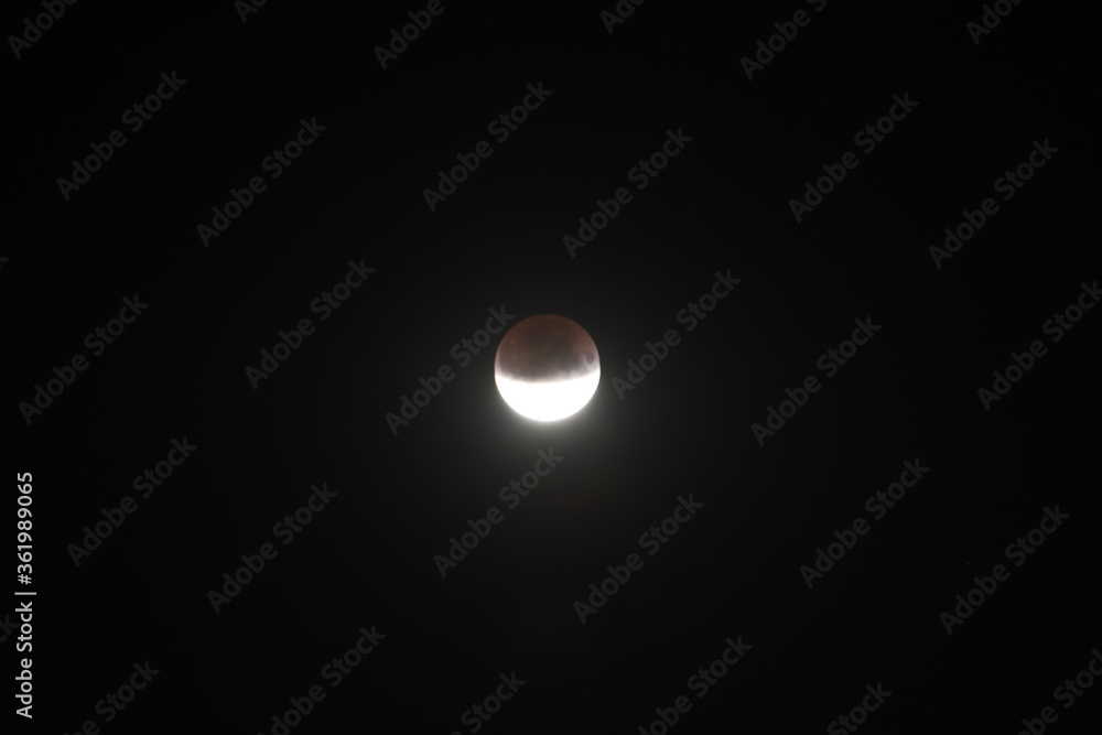 Wall mural lunar moon half eclipse on black night sky background