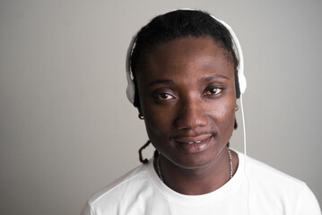 Obraz premium Face of young handsome African man with dreadlocks listening to music