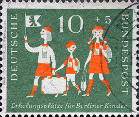 GERMANY - CIRCA 1957: This postage stamp in green shows three children with luggage and Berlin pennants. Recreation places for Berlin children is the text. circa 1957
