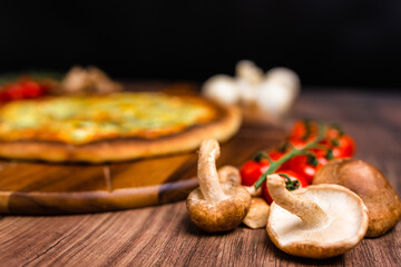 Close-up british mushrooms on a wooden table with pizza in background. Mushroom ingredient for pizza. Concept of preparing pizza with British mushrooms.