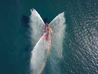 A floating modern ship sprays jets of water, demonstrates fire fighting water cannon, sprays water...