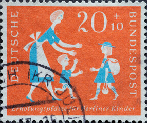 GERMANY - CIRCA 1957: This postage stamp in green shows mother with child who welcomes child with...