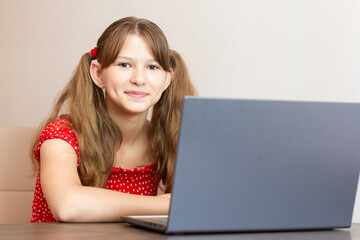 Distance learning online education. Little girl using laptop computer studying. Working at laptop...