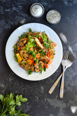 Grilled vegetables and chicken breast salad. Chicken breast, salad, mushrooms, tomatoes, orange. Top view. Free space for text. Dark background