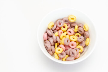 Colorful cereal on a glass bowl on white background