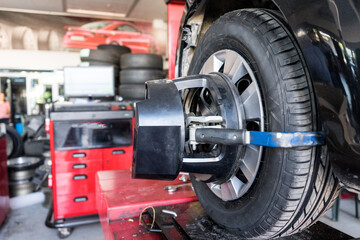 Fototapeta premium Tyre / tire fitting, rod adjustment. For the vehicle on the adjusting the tie-rod to align the wheel correctly.