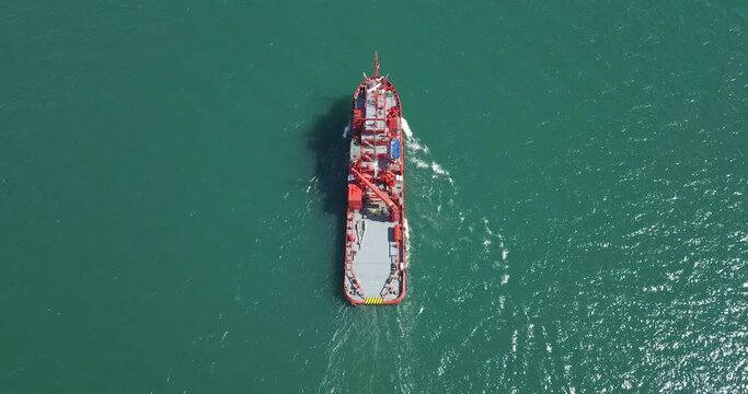 A floating modern ship sprays jets of water, demonstrates fire fighting water cannon, sprays water as firefighter boat top view from the drone