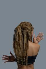 Young African American woman in black top standing back to camera, showing palms with stop racism lettering