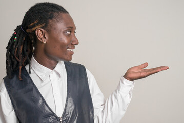 Profile view of happy young handsome African businessman with dreadlocks showing something