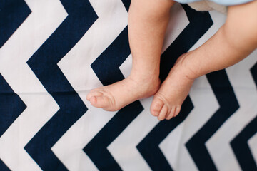 Newborn baby feet and legs. Delicate and wrinkled. Weak and scrawny feet.