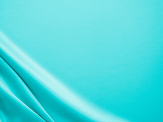 Beautiful elegant wavy turquoise silk or satin luxury cloth fabric texture, abstract background design.