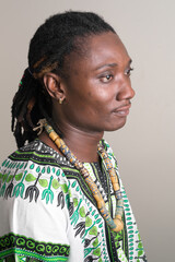 Face of young handsome African man with dreadlocks in traditional clothing thinking