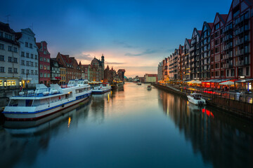 Old town in Gdansk with historical port crane over Motlawa river at rainy sunset, Poland.