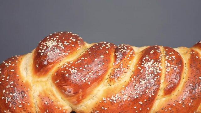 Close up of braided challah bread with sesame and poppy seeds.