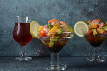 Ceviche salad with shrimps, oranges and avocado in glass bowl on a dark or grey background. Latin American food. Delicious, freshly made shrimp ceviche. Shrimp marinated in lime and orange .