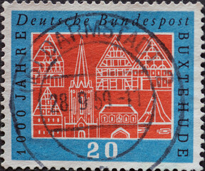 GERMANY - CIRCA 1959: a postage stamp printed in Germany is showing  the silhouette of Buxtehude Germany in white on a red background. The occasion of Buxtehude 1000 years