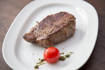Gebratenes Steak auf weißen Teller mit Tomate
