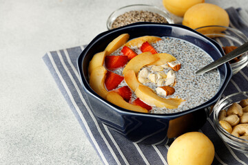 Bowl of chia poudding with pieces of apricots and strawberry