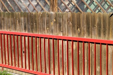 Fototapeta premium Metallic red railing with a wooden fence (Pesaro, Italy, Europe)