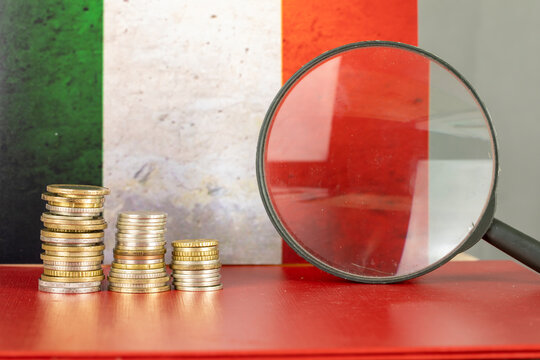 Magnifying glass and coins in front of Italia flag, country economy concept