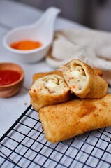 Delicious Risoles or Risol Mayo is a typical Indonesian traditional street food made from flour skin, meat and vegetables stuffing inside with mayonnaise and chili sauce.
