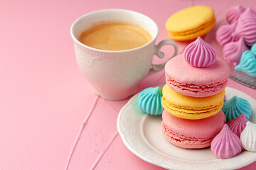 Cup of coffee with colorful cookies close up