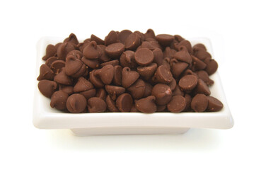 Close up pile of chocolate morsels on white background