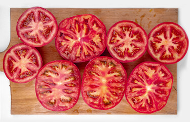 fresh ripe tomato slices on a wooden cutting board, tomatoes background