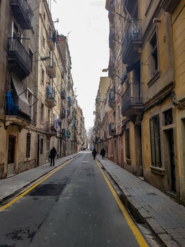 Barcelona small street road alley walk balconys flags old town Barcelonetta city center historic house buildings spain