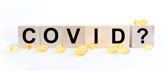 Fototapeta premium covid inscription word on wooden cube blocks on a white background. covid symptoms concept.