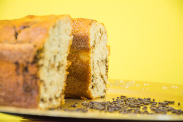 Tingling cake with chocolate on golden tray on yellow background and chocolate sprinkles
