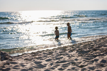 Fototapeta na wymiar Silhouettes of two boys by the sea