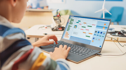 Smart Schoolboy Uses Laptop to Program Software for Robotics Engineering Class. Elementary School...
