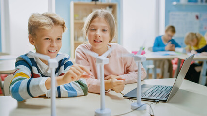 Schoolgirl and Schoolboy Work with Wind Turbine Prototype, Learning about Environment and Renewable...