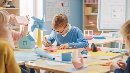 Elementary School Arts & Crafts Class: Diverse Group of Smart Children Have Fun on a Handicraft Project, Using Colorful Paper, Scissors and Glue to Build Eco Friendly House with Wind Turbine