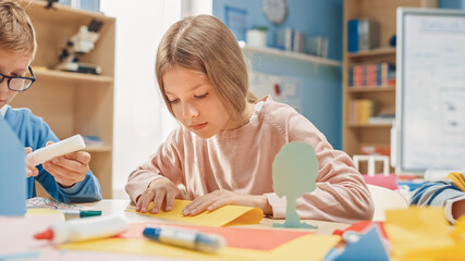 Elementary School Arts & Crafts Class: Cute Little Blond Girl Has Fun with Her Classmates on the...