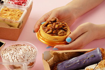 Female hands holding dessert in hands among fresh confectionary