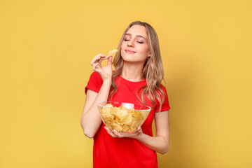 Beautiful woman with chips on yellow background