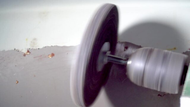 Mechanic grind old paint and rust from car body using drill with scotch brite circle in auto repair shop. Car body repair