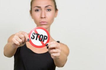 Young woman with brown hair showing stop sign