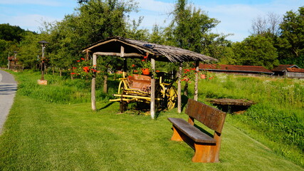 Summer view of an old wooden horse carriage in brown color, under the strow roof