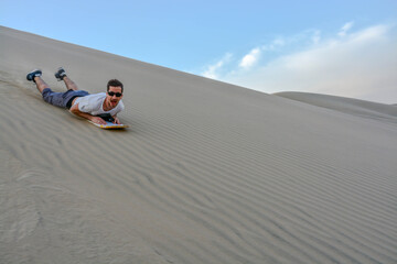 Doing sandboard in Huacachina, Peru