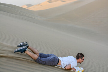 Doing sandboard in Huacachina, Peru
