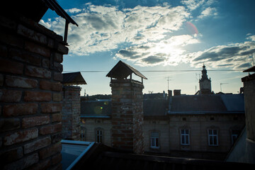 rooftop view on old historical buildings silhouettes against blue sky with white clouds