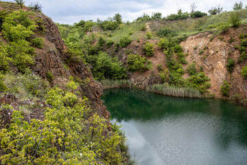 Old flooded rock quarry lake with clean transparent water