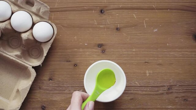 Step by step. Measuring olive oil with a tablespoon.