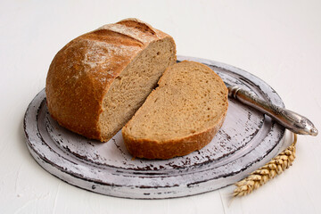 Sliced round rye bread on a wooden cutting board. Rustic still life.
