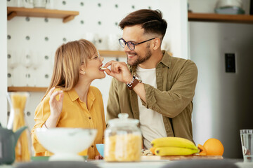 Young couple eating breakfast at home. Boyfriend and girlfriend enjoying in the morning..	