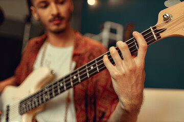 Fototapeta premium Close up of male hand playing electric guitar in the dark